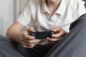 Adolescente jogando jogos eletrônicos no quarto.